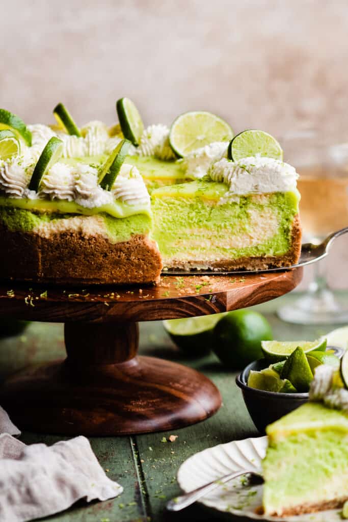 The sliced key lime cheesecake on a cake stand.