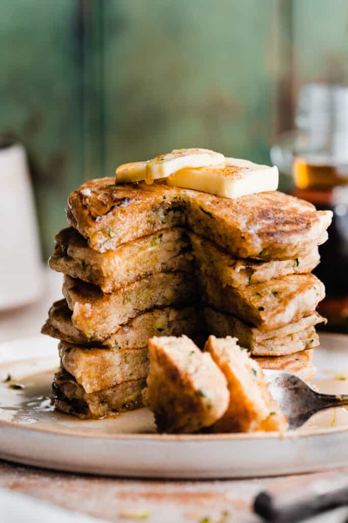 A sliced open stack of pancakes, with butter and syrup on top.