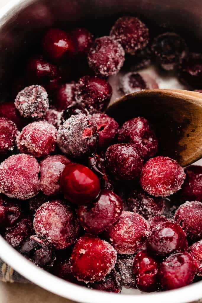 Frozen cherries and the other ingredients in a pot.