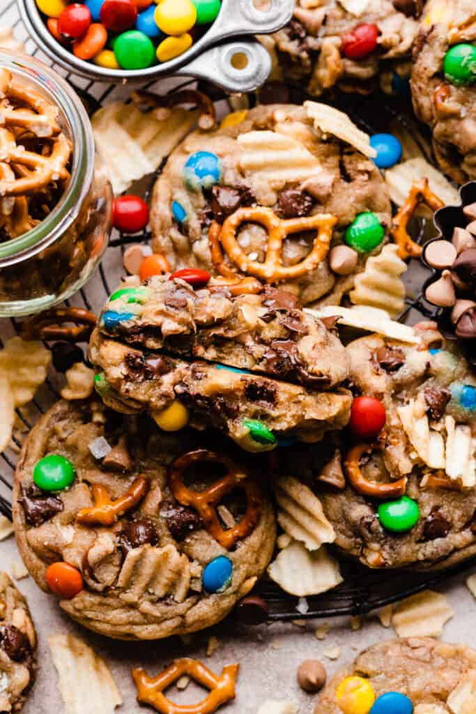 A rack of kitchen sink cookies, with visible potato chip pieces, m&ms, pretzels, and chocolate chips on top.