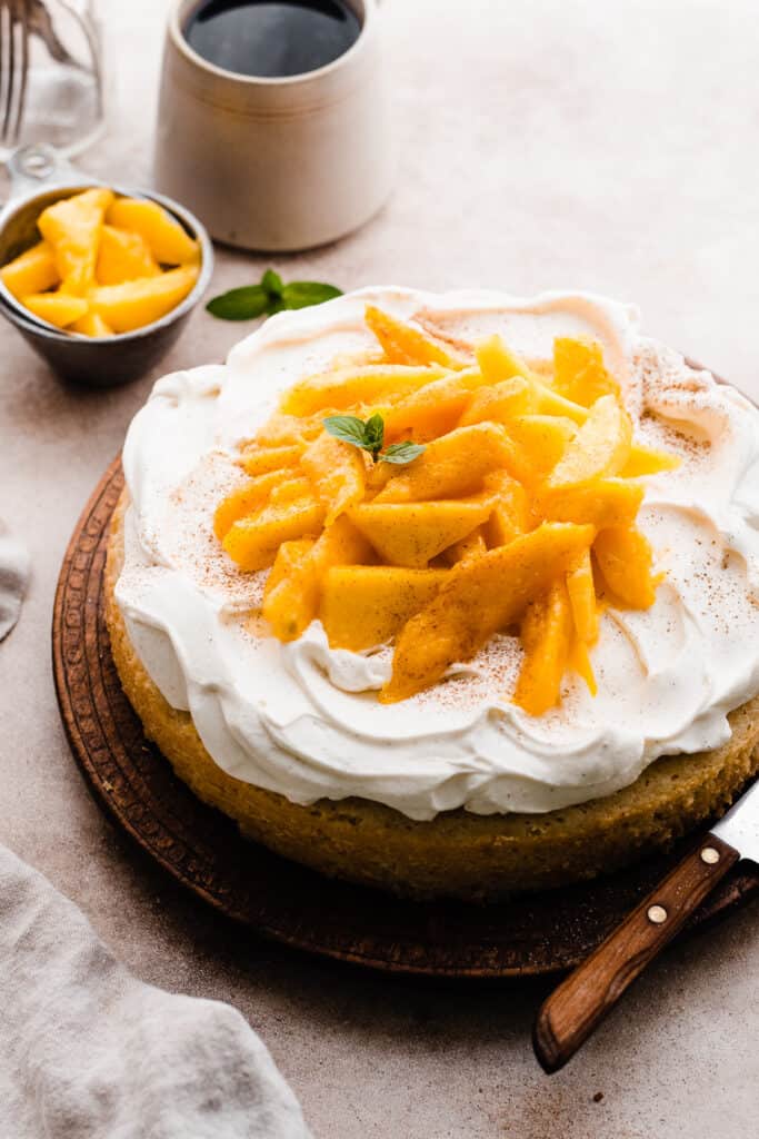 The mango cake with pillowy cream and mango slices on top.