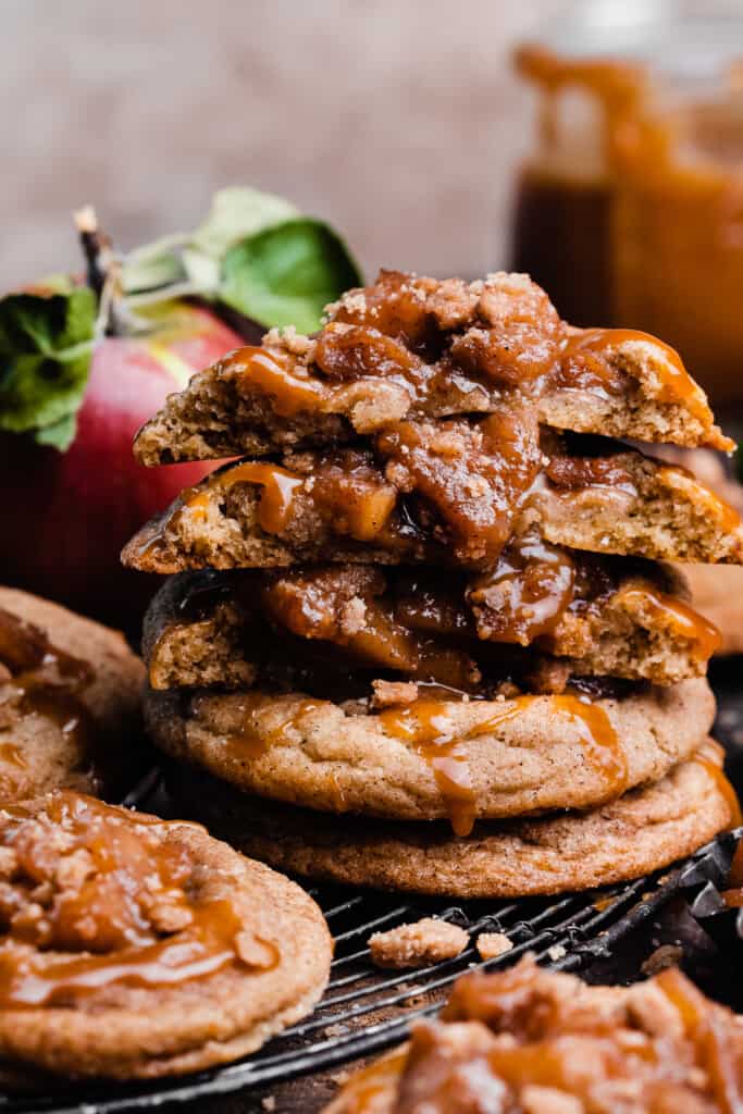 A stack of caramel apple pie cookies, with a few broken in half to show the insides. 