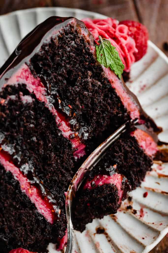A close-up of a slice of cake with a fork taking a bite.