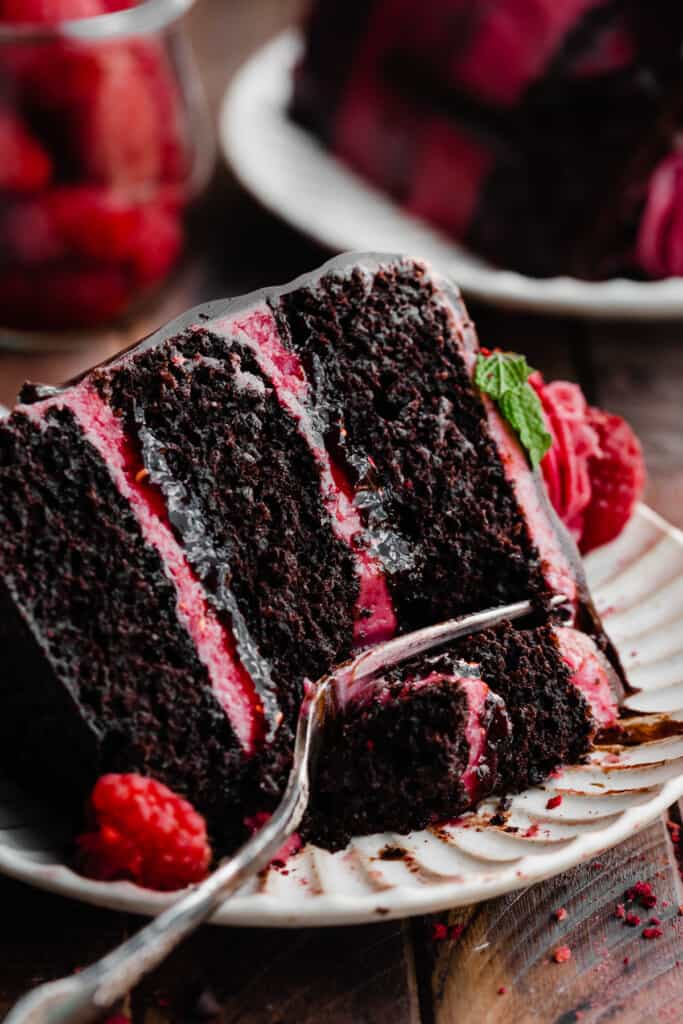 A close-up of a slice of raspberry chocolate cake on a plate.
