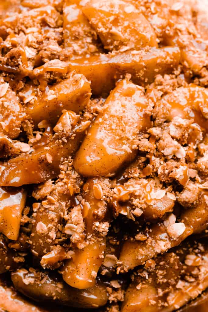 A close-up of the top of the cheesecake - showing apple slices, crumble, and caramel drizzle.