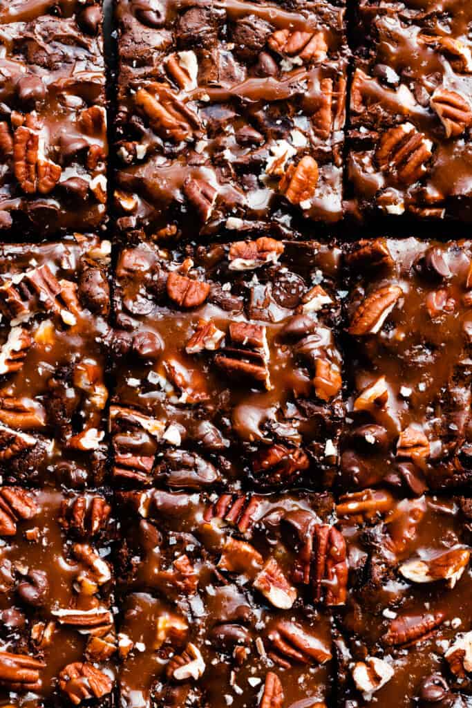 A close-up on the rows of sliced brownies, topped with salted caramel sauce.