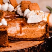 A slice of pumpkin pie cheesecake topped with salted caramel sauce and whipped cream.