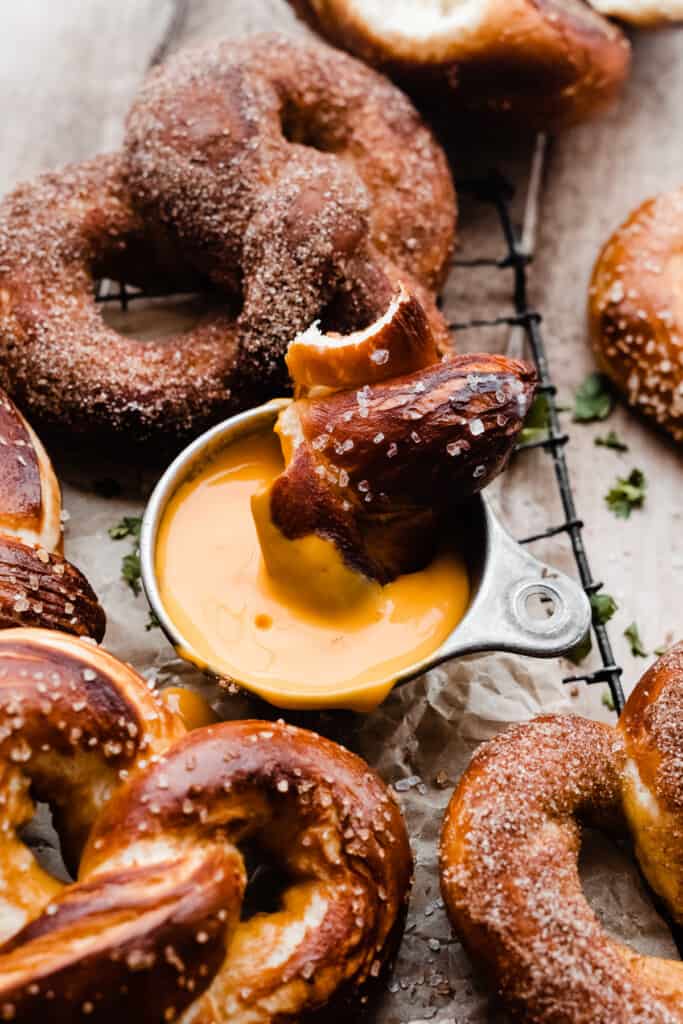 A pretzel piece dipped in cheese sauce.