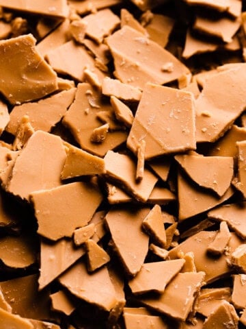A close-up of chunks of caramelized white chocolate. The pieces are a deep caramely color.