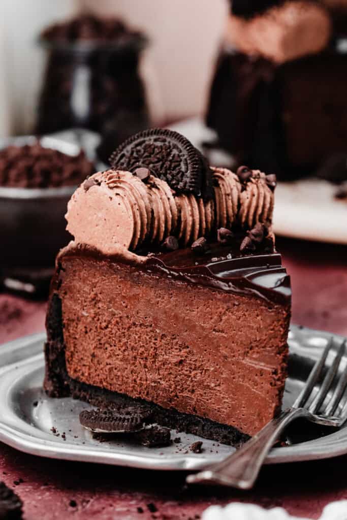 A slice of triple chocolate cheesecake on a plate.