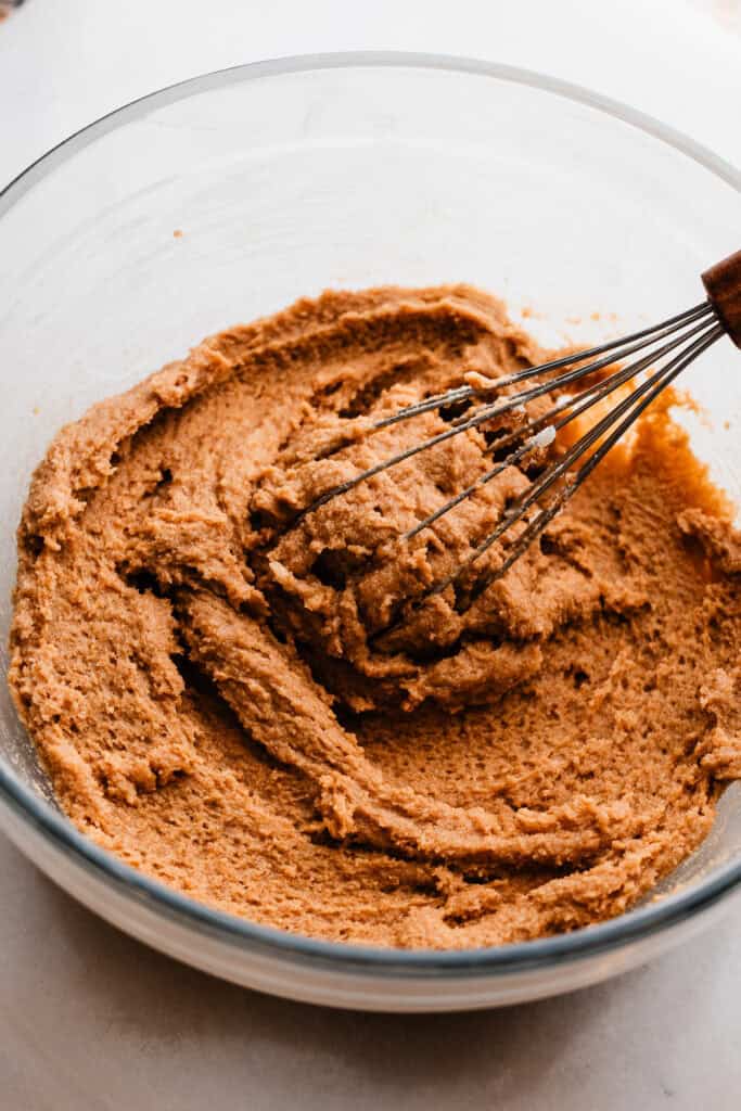 A bowl of a thick mixture consisting of the sugars whisked into the butter.