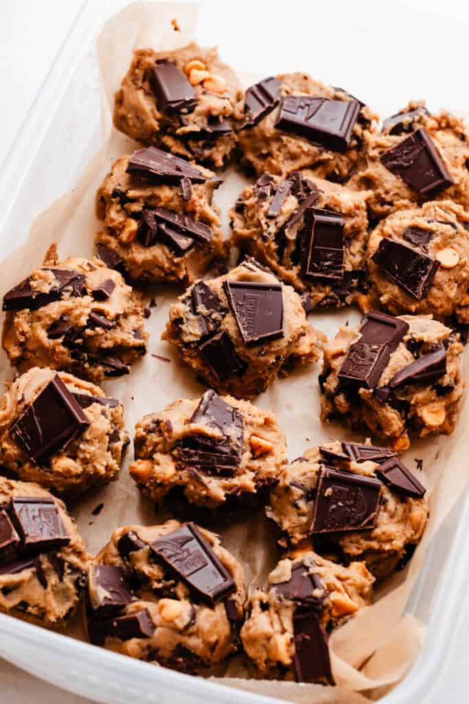 A tupperware container full of the chilled cookie dough balls.