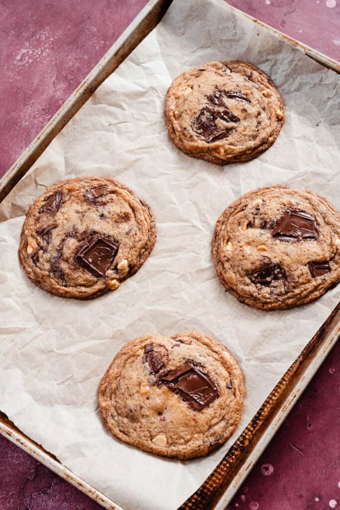 Four puffy cookies on a baking sheet, before the final pan bang.