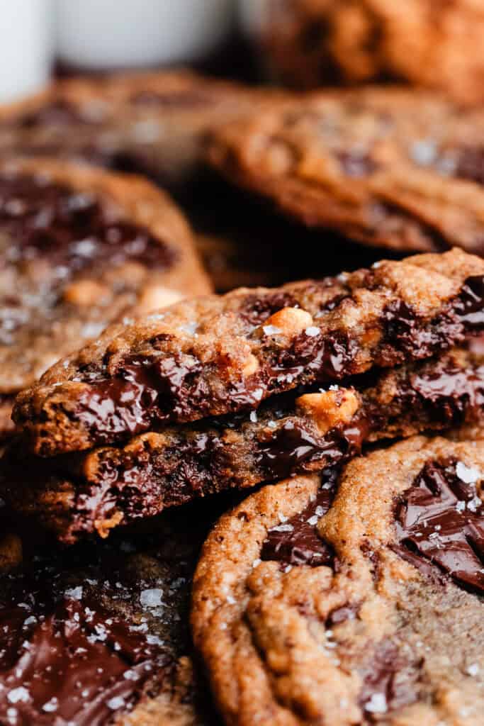 Two halves of a butterscotch chocolate chip cookie - with melty pockets of chocolate visible inside.