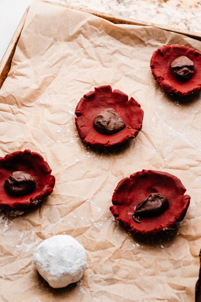 Frozen nutella dollops being rolled inside of the dough balls.