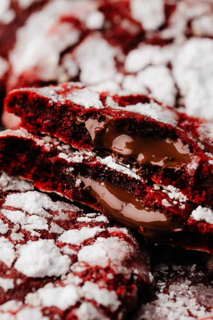 A close-up on two halves of a cookie, showing the molten nutella inside.