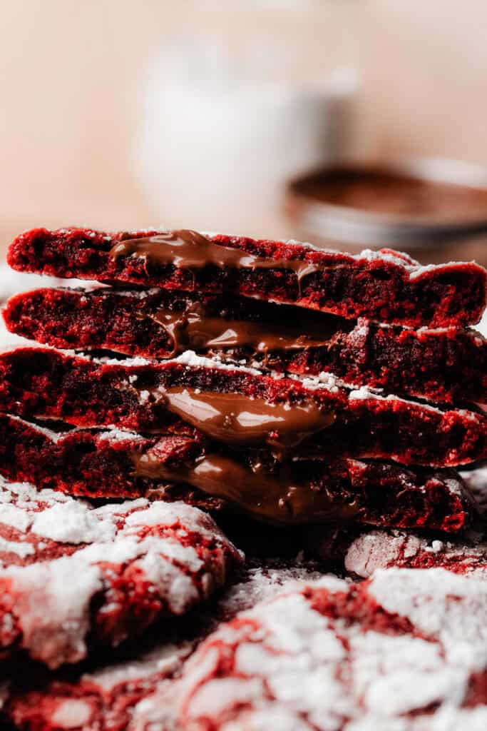 A stack of red velvet cookie halves, each one oozing with molten nutella!
