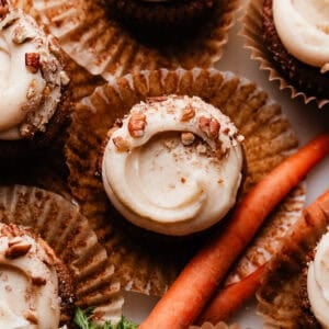 A bird's eye view of the frosted Carrot Cake Cupcakes, with beautiful swoops in the frosting and crushed pecans on top.