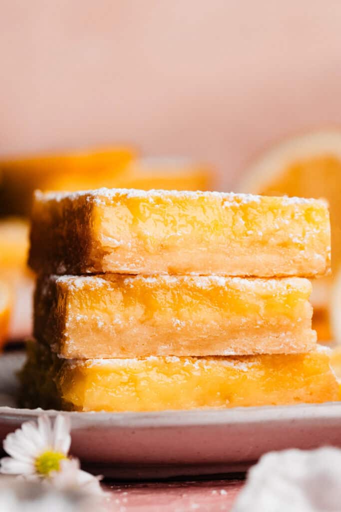 A stack of three lemon bars on a plate.